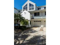 Exterior of townhouse with attached garage, manicured landscaping and updated windows at 9920 Indian Key Trl # 29, Seminole, FL 33776