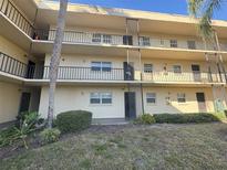 Multi-level condo complex with balconies, mature trees, and well-maintained landscaping at 11485 Oakhurst Rd # 1200-2, Largo, FL 33774