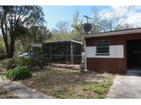 Backyard view of the house with screened in porch at 13924 Morgan St, Dade City, FL 33525