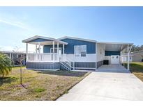 Charming blue and white home with a covered porch and carport, perfect for enjoying the outdoors at 204 El Prado, North Port, FL 34287