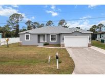 Charming single-story home with a well-maintained front yard and a two-car garage at 6131 Tedder St, Port Charlotte, FL 33981