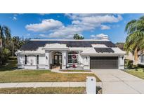 Charming single-story home with well-maintained lawn, solar panels and mature trees at 1123 Hounds Run, Safety Harbor, FL 34695