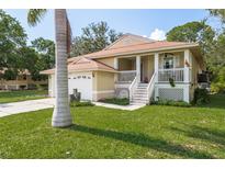 Inviting home with front porch, lush lawn, and attached garage at 1312 Gulf Rd, Tarpon Springs, FL 34689