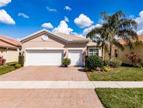 Charming single-story home with a three-car garage, brick driveway and manicured landscaping at 16243 Cape Coral Dr, Wimauma, FL 33598