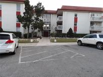 Attractive condo building with a red roof and ample parking on a quiet street at 2623 Seville Blvd # 111, Clearwater, FL 33764