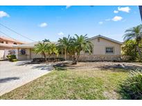 Charming single-story home featuring a well-maintained lawn and mature palm trees adding curb appeal at 448 79Th S St, St Petersburg, FL 33707