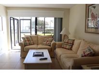 Bright living room featuring tile floors, cozy sofas, and sliding glass doors to a water view at 6287 Bahia Del Mar Cir # 101, St Petersburg, FL 33715