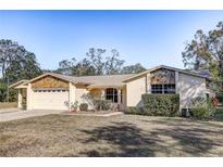 Charming single-story home with stone accents, a two-car garage, and a well-maintained front yard at 709 Lanewood Dr, Seffner, FL 33584