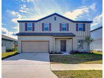 Charming two-story home with a two-car garage and a well-maintained front yard at 712 Ocean Spray Dr, Ruskin, FL 33570