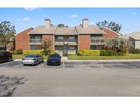 Condo building featuring a brick facade, screened balconies, and ample parking in a well-maintained community at 9100 Mlk N St # 201, St Petersburg, FL 33702