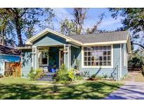 Charming blue home showcasing inviting front porch and mature trees at 1208 E Giddens Ave, Tampa, FL 33603
