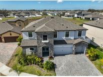 Stunning two-story home with stone accents, well-manicured landscaping, and a paved driveway at 12779 Fisherville Way, Riverview, FL 33579