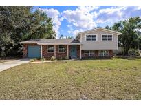 Charming two-story home featuring a brick facade, blue door, and well-maintained lawn at 407 Cranberry Ln, Brandon, FL 33510