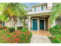 Inviting condo front entrance with lush landscaping and bright, teal colored doors at 8926 Manor Loop # 207, Lakewood Ranch, FL 34202