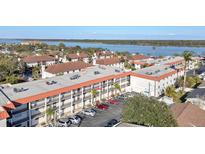 Condominium exterior featuring a terracotta roof, palm trees, and parking at 10540 77Th Ter # 209, Seminole, FL 33772