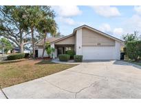 Charming single-Gathering home featuring a well-maintained lawn, mature trees, and a two-car garage at 11308 Pocket Brook Dr, Tampa, FL 33635