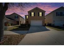 Two-story home with a front lawn and a two-car garage under a colorful, twilight sky at 12239 Fawn Brindle St, Riverview, FL 33578