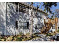 Condo exterior showing siding, front windows with shutters, and a wooden staircase to the front door at 5699 67Th N Ave # 124, Pinellas Park, FL 33781