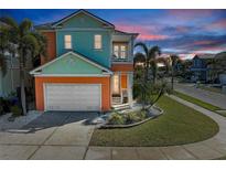 Charming two-story home boasts vibrant colors, a two-car garage, and a welcoming front porch, perfect for coastal living at 6571 Simone Shores Cir, Apollo Beach, FL 33572