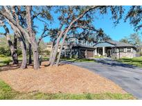 Charming two-story home with a stone facade, two-car garage, balcony, and manicured lawn at 9250 Rhea Dr, Odessa, FL 33556