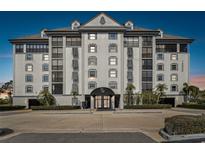 Elegant building exterior featuring multiple stories, balconies, and meticulously maintained landscaping at 14820 Rue De Bayonne # 205, Clearwater, FL 33762