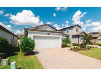 Charming single-Gathering home featuring a two-car garage and a well-manicured lawn with mature landscaping at 20092 Stone Pine Cir, Lutz, FL 33558