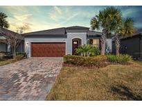 Charming single-story home featuring a brick driveway, a two-car garage, and a well-manicured front yard at 31837 Cannon Rush Dr, San Antonio, FL 33576