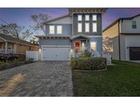 Charming two-story home featuring a brick driveway, well-kept lawn and an inviting front door with seasonal decor at 7403 S Obrien St, Tampa, FL 33616