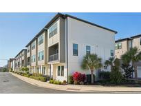 Modern townhouse exterior with a small balcony and colorful, well-maintained landscaping at 2511 N Grady Ave # 41, Tampa, FL 33607