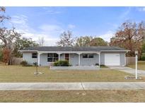 Charming single-story home with a well-maintained lawn, covered porch, and attached garage, offering curb appeal at 4553 Kirkland Ave, Spring Hill, FL 34606