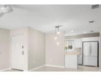 Open-concept living space with pendant lighting and view of kitchen featuring white appliances at 4215 E Bay Dr # 1601D, Clearwater, FL 33764