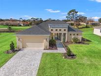 Charming single-Gathering home featuring manicured lawns, a two-car garage, and a welcoming walkway at 8977 Players Dr, Brooksville, FL 34613