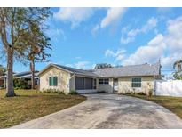 Charming single-story home with a well-manicured lawn, a circular driveway, and a screened-in porch at 10906 Covey Ct, Tampa, FL 33625