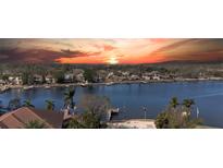 Waterfront homes with docks line the tranquil bay under a vibrant sunset sky at 1118 Monterey Ne Blvd, St Petersburg, FL 33704