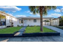 Charming single-story home with a well-manicured front yard and a lovely palm tree at 2540 W Pine St, Tampa, FL 33607
