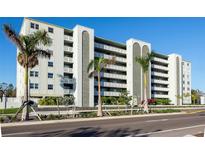 Multi-story building featuring private balconies, palm trees, and well-maintained landscaping at 7321 Central Ave # 402, St Petersburg, FL 33710