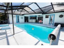 Relaxing pool area with a screened enclosure, offering both sun and shade for comfortable outdoor living at 8979 Hernando Way, Weeki Wachee, FL 34613