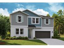 Charming two-story home featuring a two-car garage, well-manicured lawn, and stylish gray and blue siding at 12148 Cattleside Dr, Riverview, FL 33579
