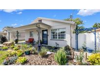 Charming home featuring a cozy front porch, inviting garden, and delightful blue pergola detail at 2404 N Lincoln Ave, Tampa, FL 33607