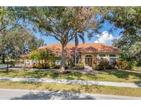 Charming single-story home with lush landscaping, a terracotta roof, and a welcoming facade at 7185 N Serenoa Dr, Sarasota, FL 34241