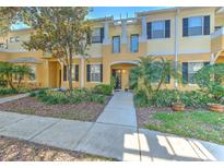Charming two-story townhome with a landscaped front yard and inviting entryway at 7570 Tamarind Ave, Tampa, FL 33625