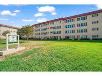 Residential building with well-maintained lawn and landscaping under a sunny sky at 9950 62Nd N Ter # 104, St Petersburg, FL 33708