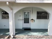 Welcoming front door with a hanging plant, complemented by windows on either side at 11200 102Nd Ave # 125, Seminole, FL 33778