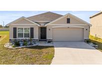 Charming single-story house featuring a two-car garage, manicured lawn, and inviting facade at 2839 Gumbo Limbo Dr, Wimauma, FL 33598