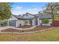 Charming one-story home with a beautifully landscaped front yard, fresh mulch, and healthy plants at 3038 Longbrooke Way, Clearwater, FL 33760