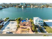 Waterfront property featuring a pink home next to a two-story home in a coastal community at 329 55Th Ave, St Pete Beach, FL 33706