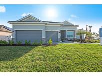 Charming single-story home featuring a manicured lawn, a two-car garage, and elegant landscaping at 7970 Lakes Edge Ln, Port Charlotte, FL 33981