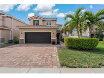 Charming two-story home with a well-manicured lawn, beautiful red brick driveway and tile roof at 10136 Grand Oak Cir, Madeira Beach, FL 33708