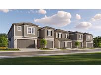 Exterior of new townhomes with neutral color palette, garages, and landscaping on a sunny day at 10807 Fort White Ct, Tampa, FL 33647
