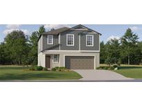 Charming two-story home with blue siding, a well-manicured lawn, and an attached two-car garage at 9452 Runaway Breeze Dr, Land O Lakes, FL 34637